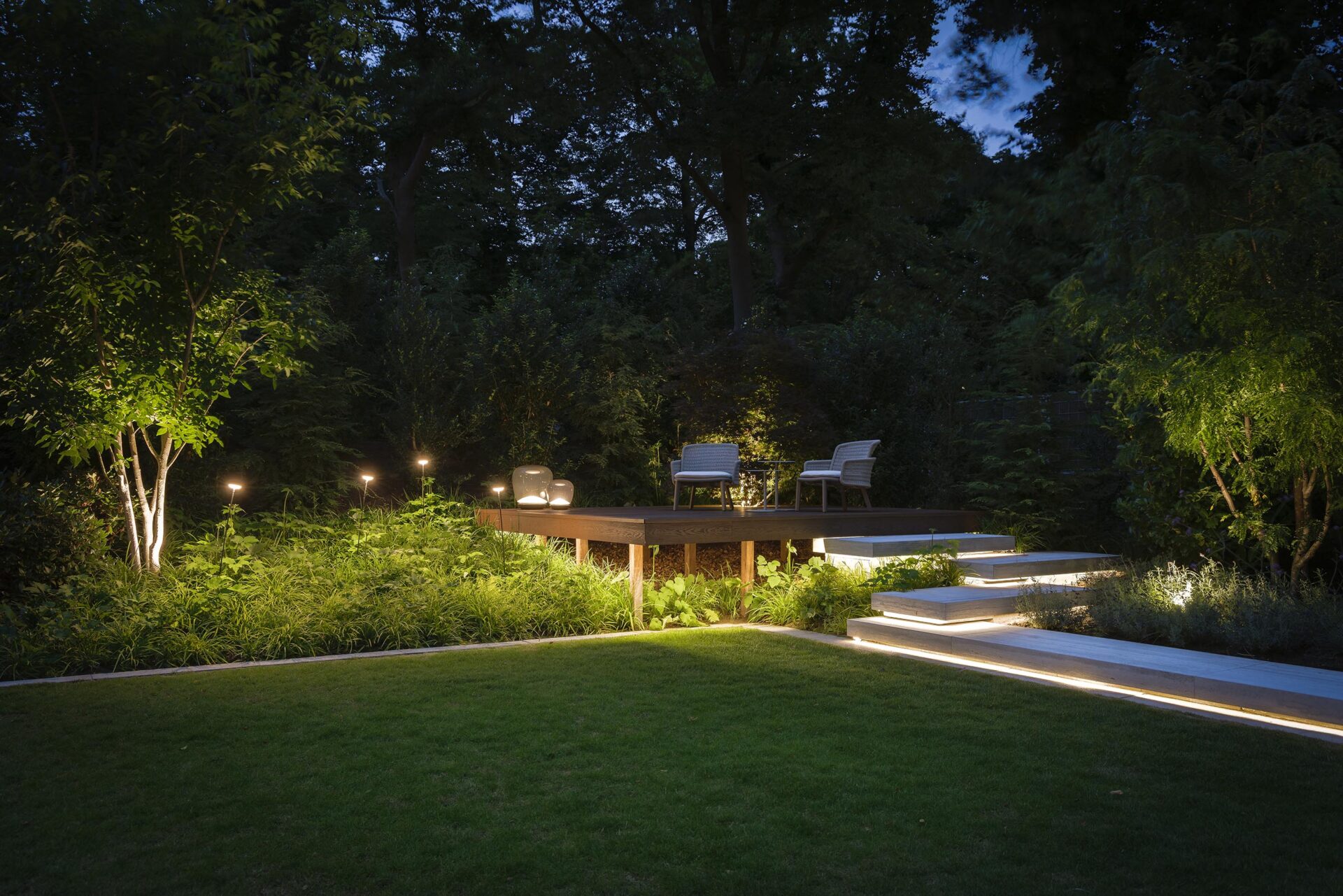 Villatuin Hilversum in de avond met fraaie verlichting bij traptreden en bij beplanting. 