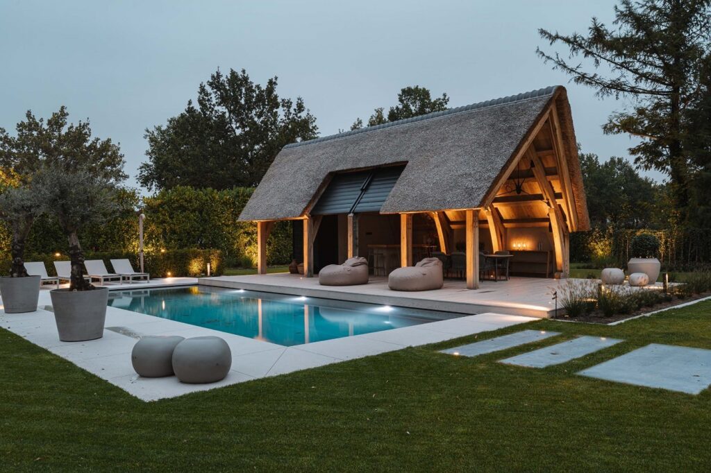 Tuinontwerp kaatsheuvel met zicht op de moderne poolhouse en het zwembad.