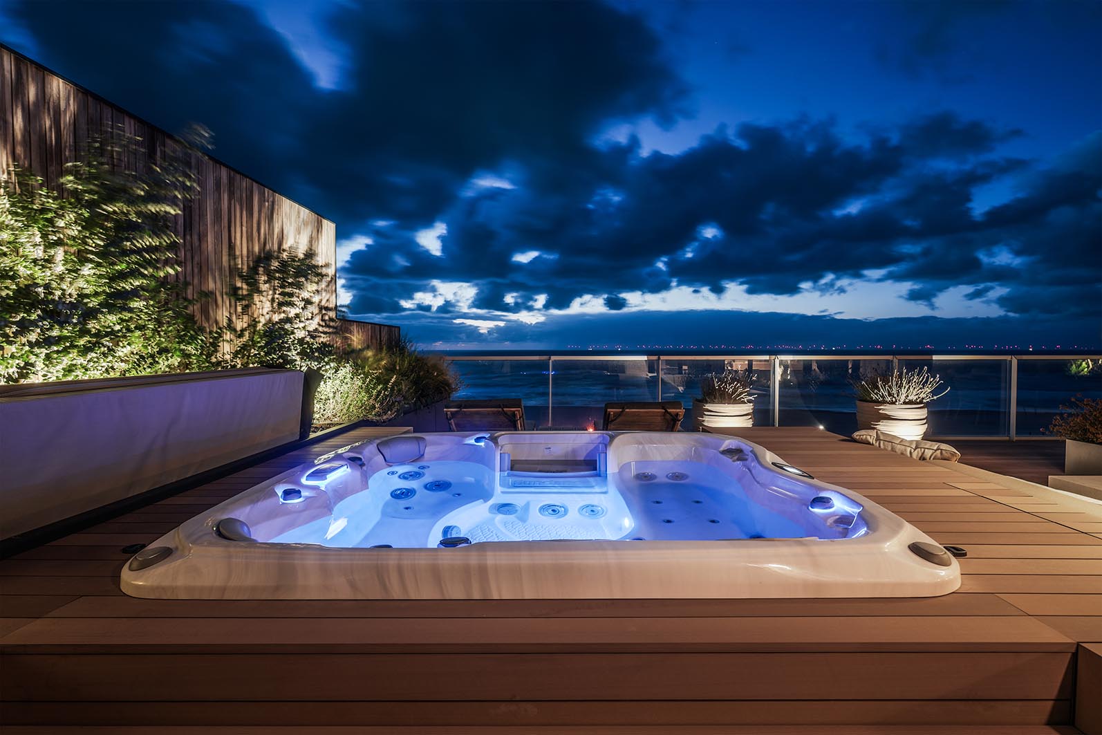 Avondbeeld over de jacuzzi met verlichting onder water van de daktuin in Kijkduin. 