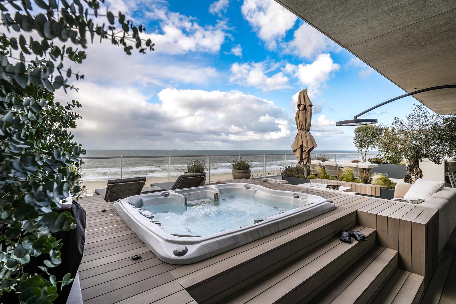 Daktuin Kijkduin met zicht op de jacuzzi met vlondertrap en uitzicht over zee. 