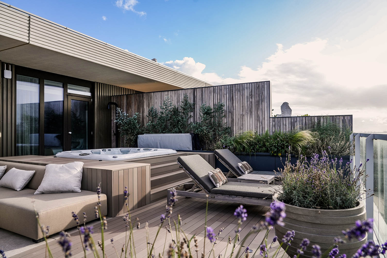 Daktuin Kijkduim met zicht op de ligbedden die naar de zee uitkijken en daarachter de jacuzzi.